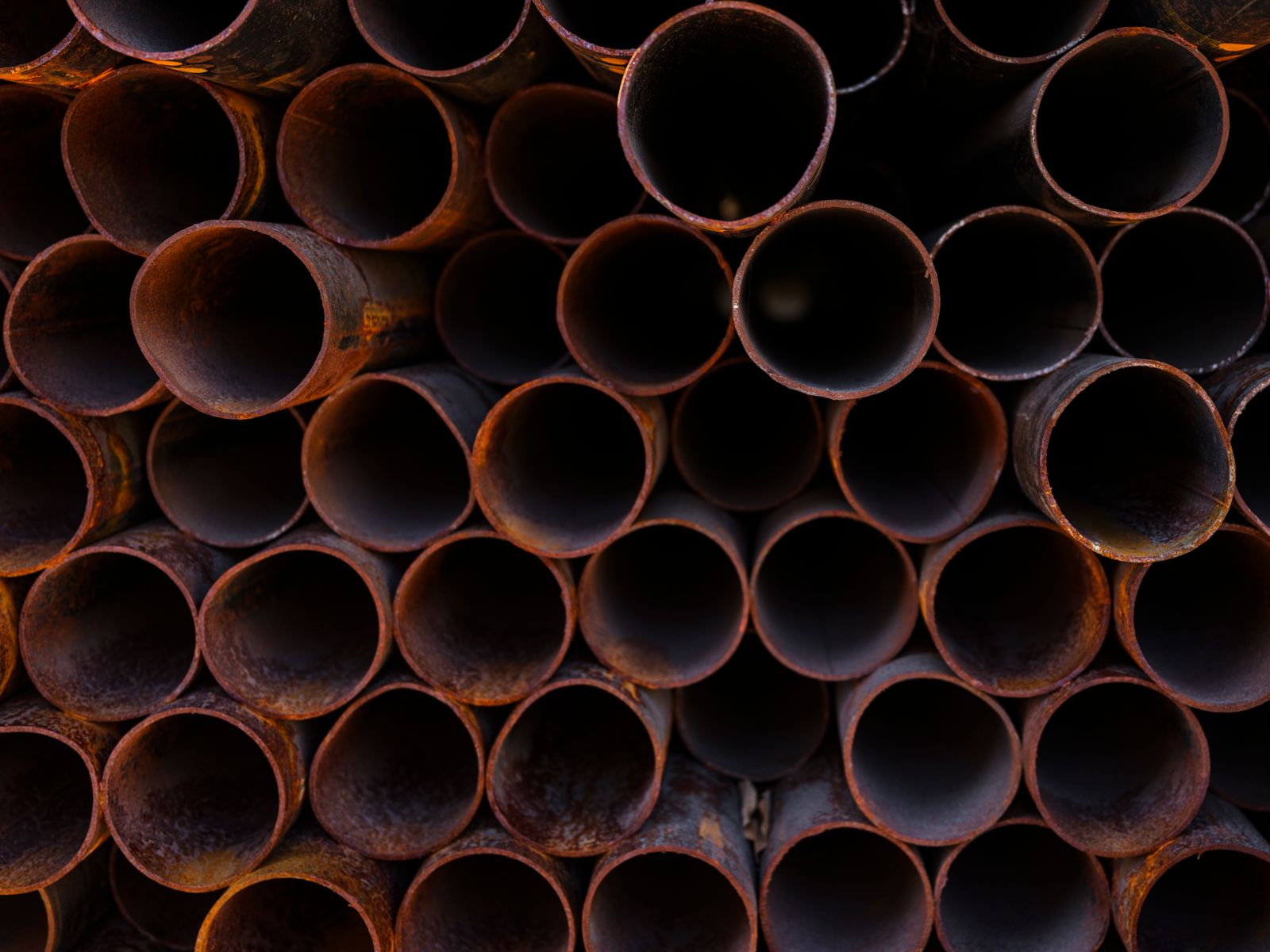 Close-up of stacked steel pipe ends in a storage yard